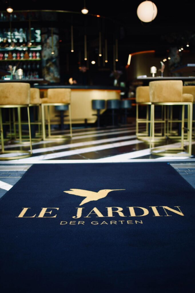 Logomatte von EDER Mat Couture mit der Aufschrift Le Jardin – Der Garten im Eingangsbereich eines Restaurants.